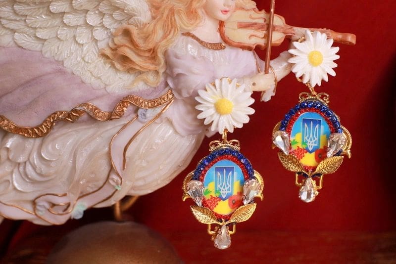 A pair of earrings with a picture of an angel.