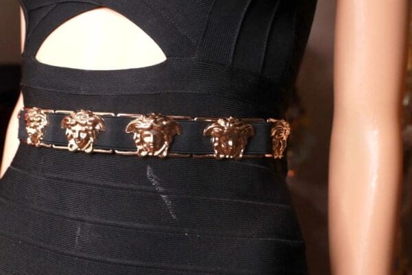 A close up of the versace belt on a woman 's dress