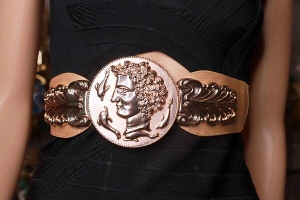 A woman wearing a belt with a face on it.