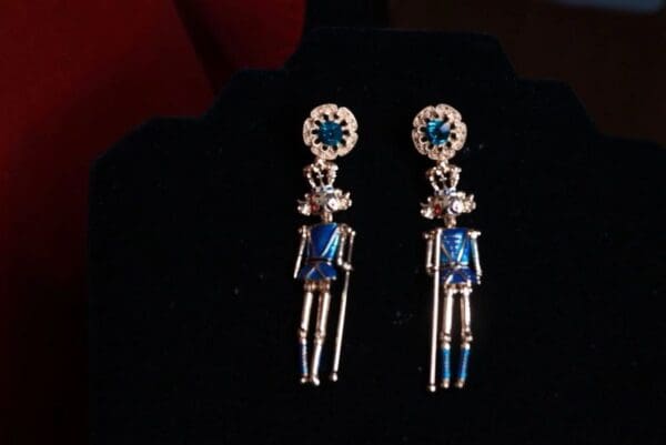 A pair of earrings with blue and white figurines.
