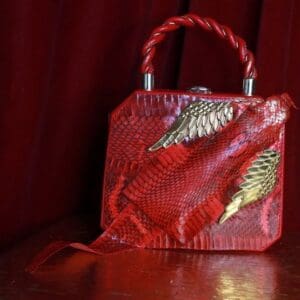 A red purse sitting on top of a wooden table.