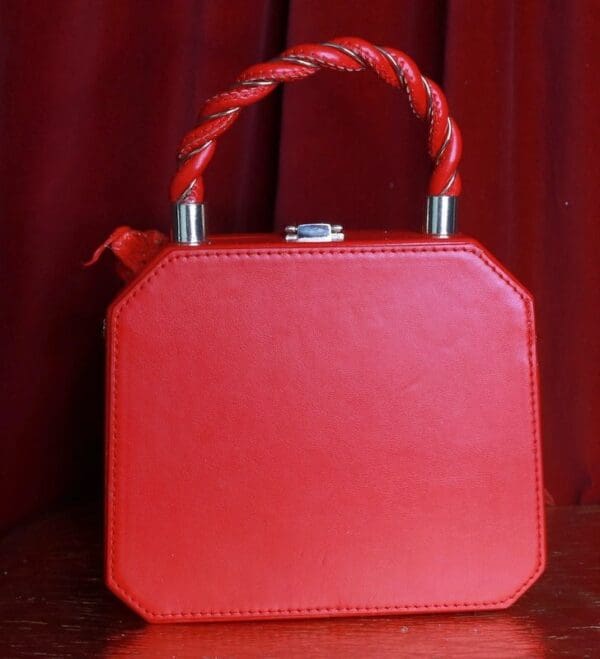A red purse sitting on top of a table.