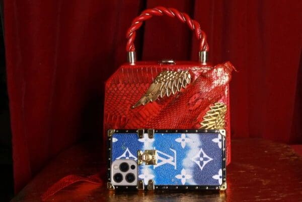 A red purse and a blue bag sitting on top of a table.
