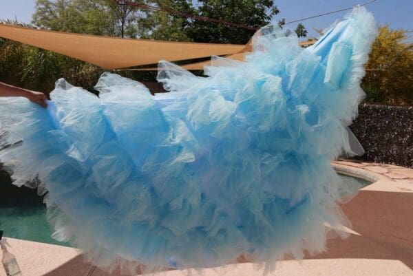 A blue skirt is blowing in the wind.