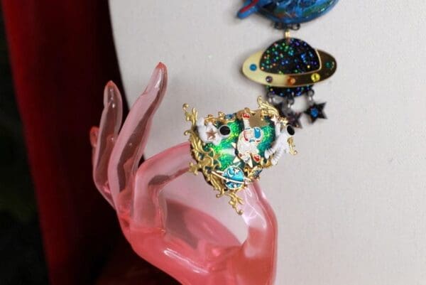 A pink hand with some jewelry on it