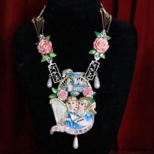 A necklace with pink roses and a picture of two people.