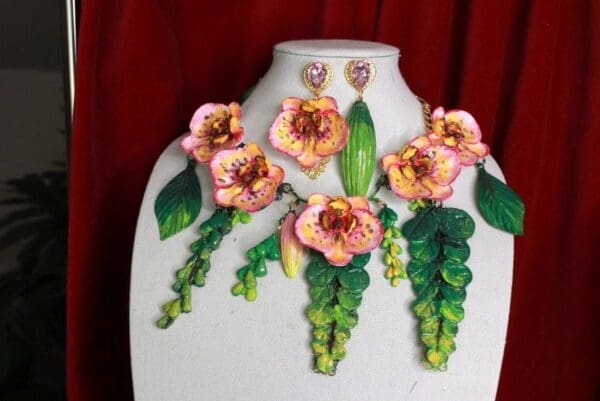 A white mannequin with pink flowers and green leaves.