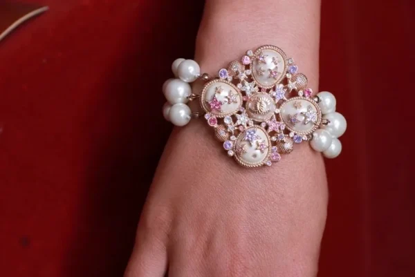 A woman wearing a bracelet with pearls and beads.