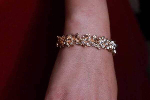 A woman 's arm with a gold bracelet on it.