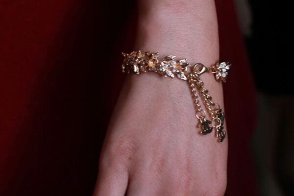 A woman wearing a bracelet with charms on it.