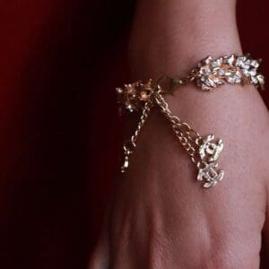 A woman 's hand wearing a bracelet with chains.