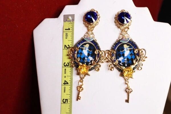 A pair of earrings with a key and a picture on them.