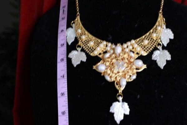 A necklace with leaves and pearls on it