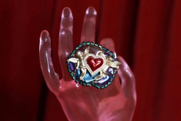 A hand holding something with a heart on it.