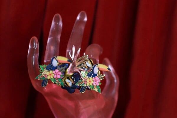 A hand with two colorful birds on it