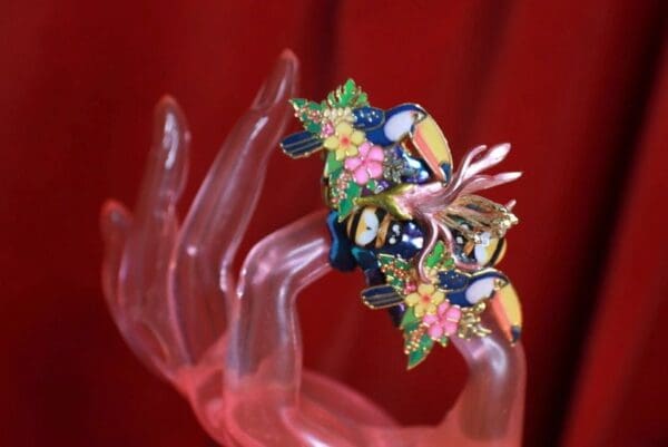A hand holding something with colorful flowers on it.