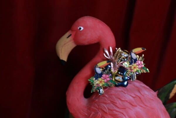 A pink flamingo with flowers on its head.