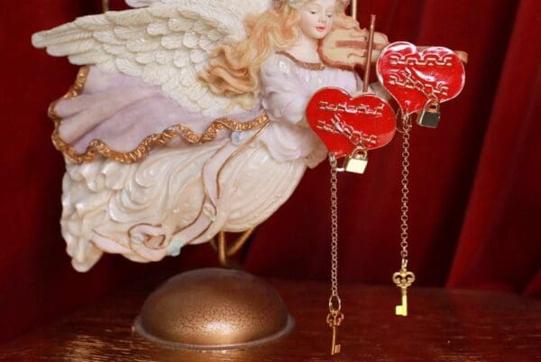 A statue of an angel holding two hearts and keys.