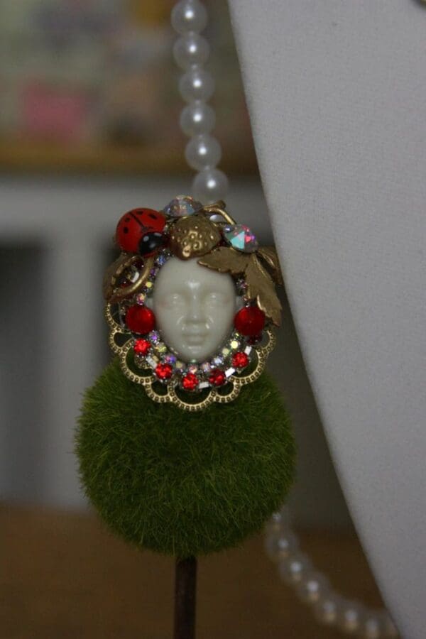 A close up of a necklace with a face on it