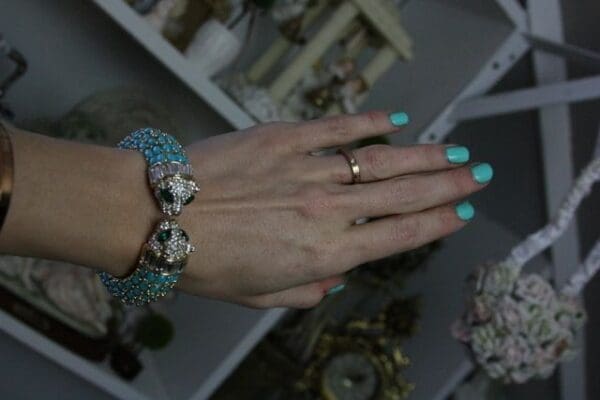 A woman 's hand with two rings on her fingers.
