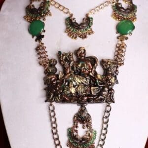 A necklace with green stones and gold chains.