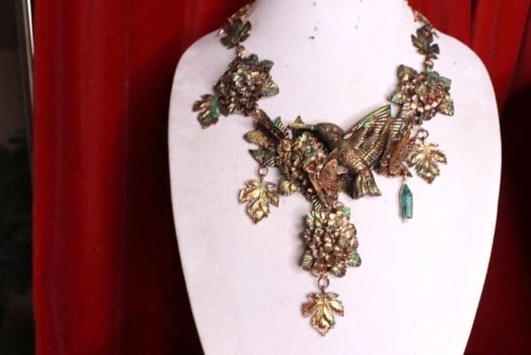 A necklace with leaves and a turquoise bead.