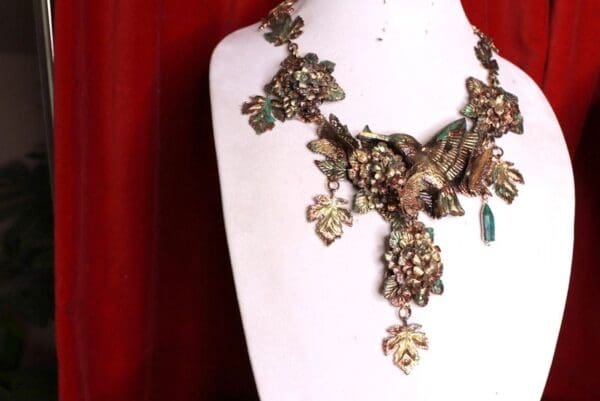 A necklace with leaves and birds on it
