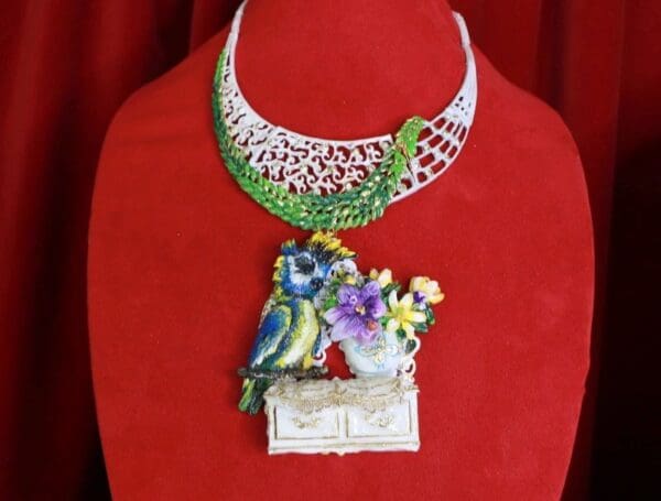 A necklace with a bird and flowers on it