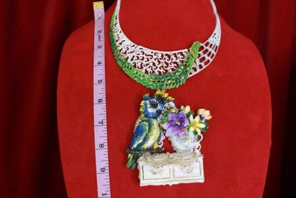 A necklace with a bird and flowers on it
