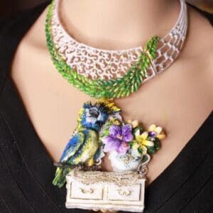 A woman wearing a necklace with a bird on it.