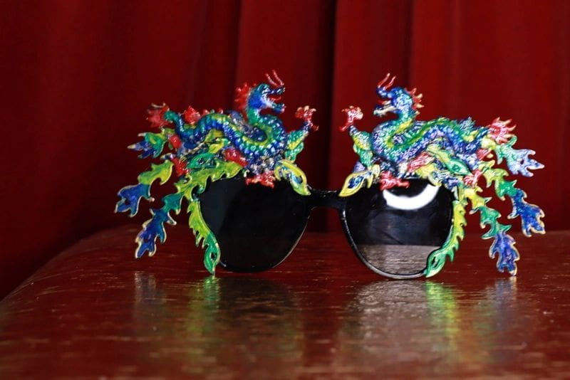 Two colorful peacocks are sitting on top of a table.