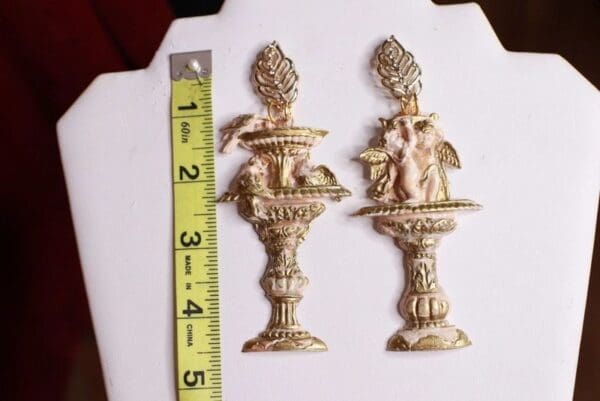 A pair of antique brass candle holders with figures.
