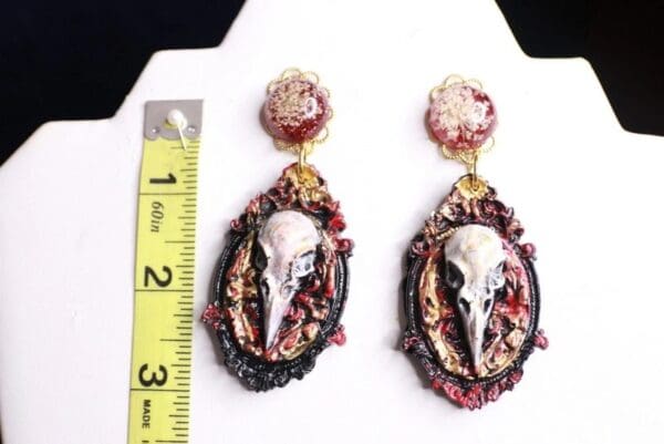 A pair of earrings with a bird 's head on them.
