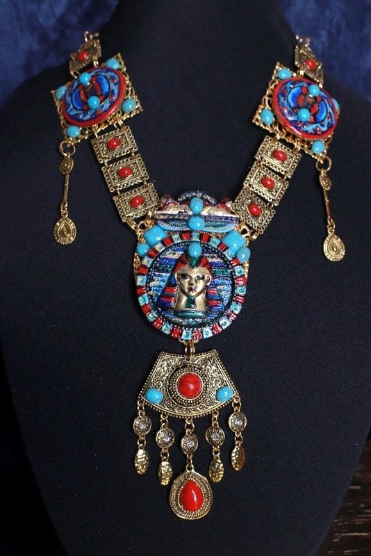 A necklace with a face on it and some tassels