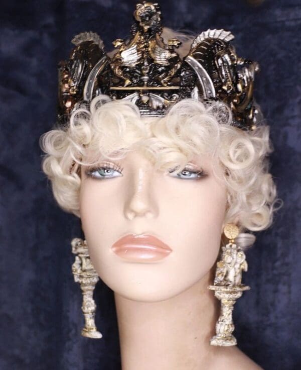 A mannequin head with a crown and earrings.