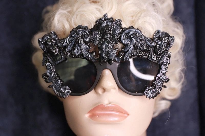 A mannequin wearing sunglasses with ornate design.
