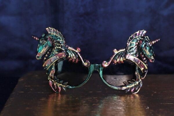 A pair of green and pink unicorn sunglasses.