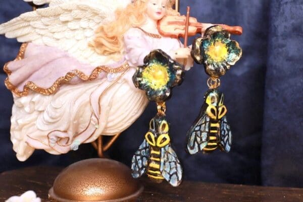 A pair of earrings with bees on them.