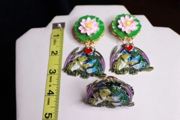 A pair of earrings and a brooch are shown.