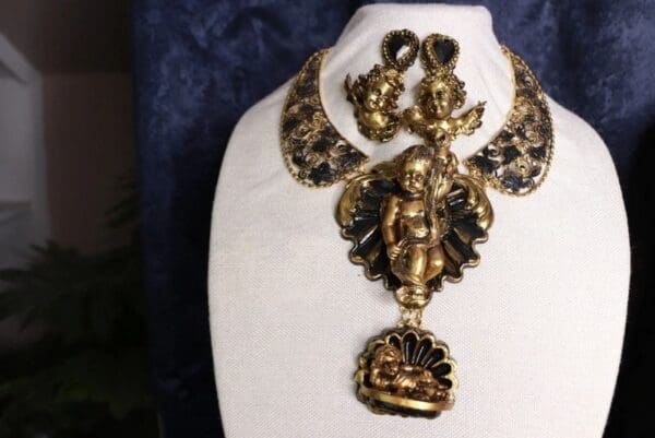 A necklace with an angel on it and a crown.