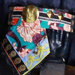 A pair of colorful scarves with a gold medallion on top.