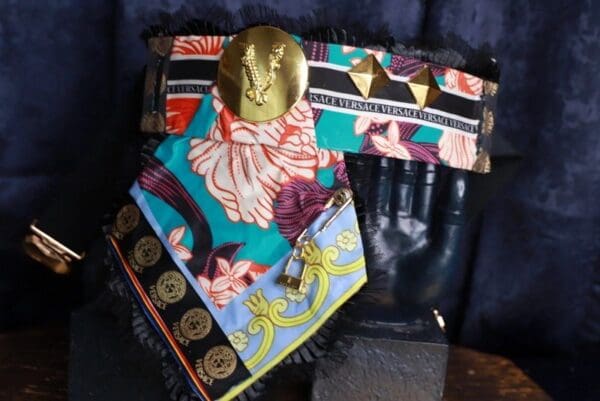 A pair of colorful scarves with a gold medallion on top.