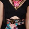 A woman wearing a black dress and colorful scarf.