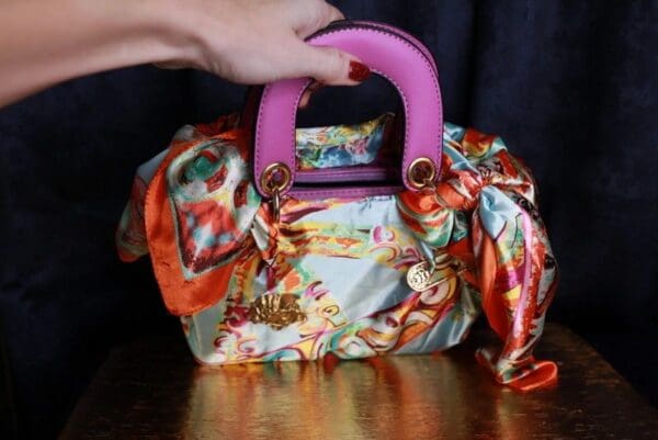 A woman is holding onto the handle of her purse.