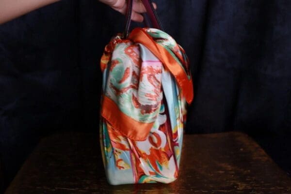 A person holding onto the handle of a bag