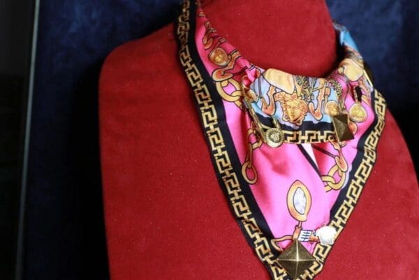 A red shirt with a pink scarf and clock on it