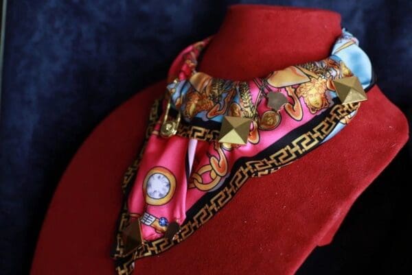 A red and gold scarf with a clock on it