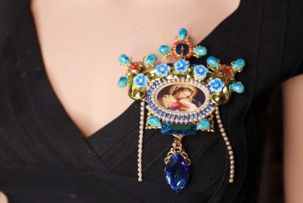 A woman wearing a black dress with blue jewelry.