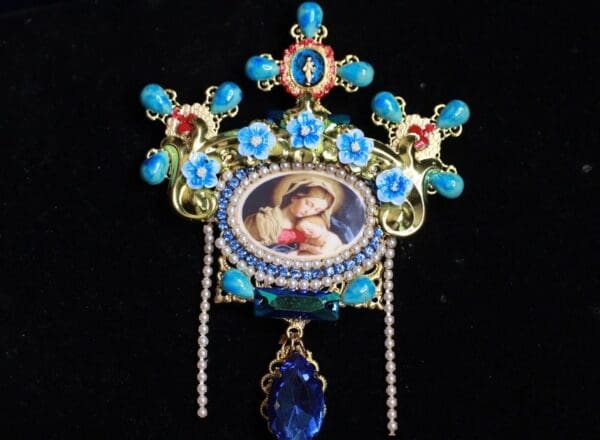 A blue and red brooch with a picture of a woman.