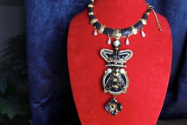 A red velvet display with a necklace and pendant.